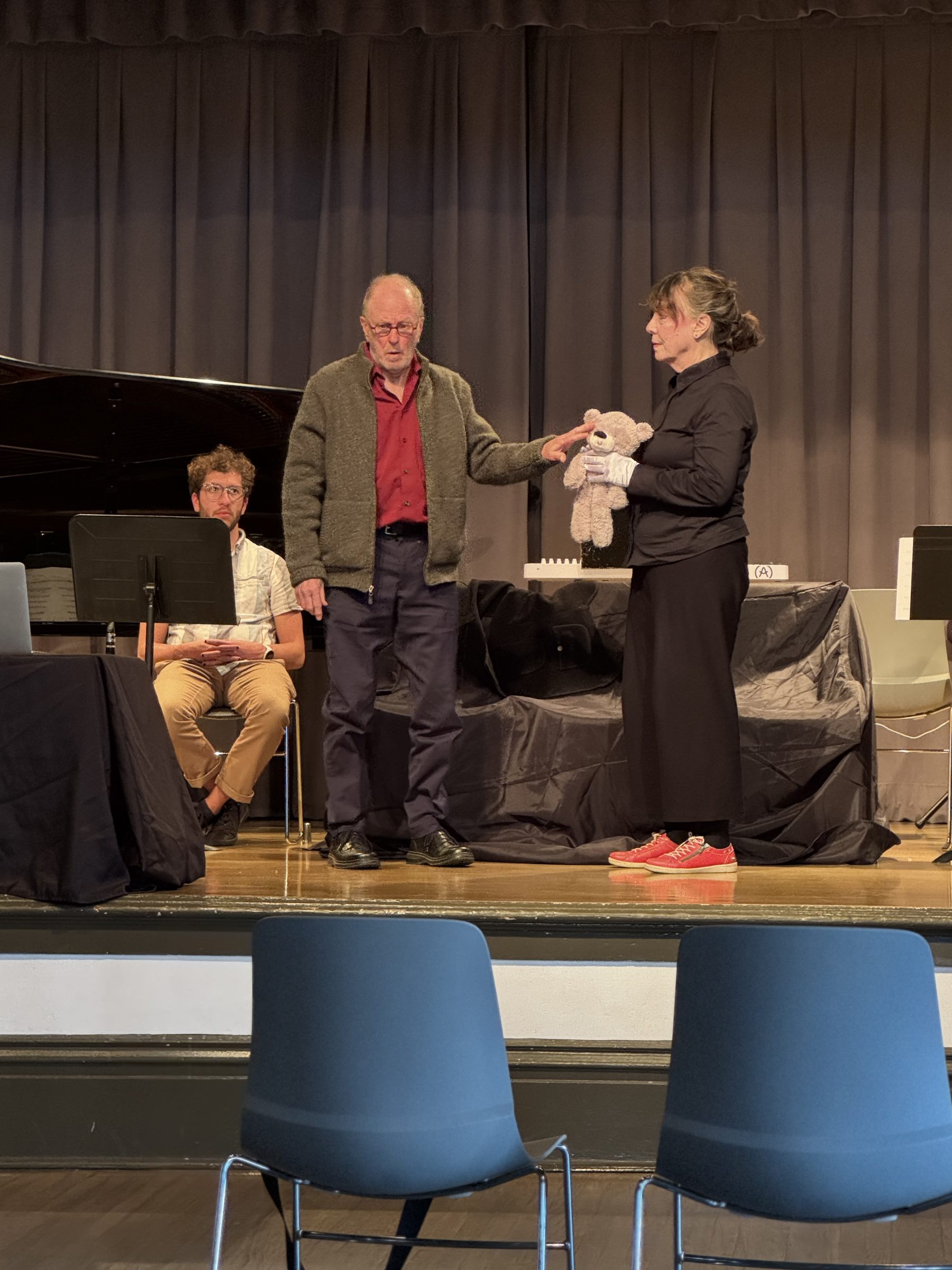 The two performers exchanging the teddy bear on stage